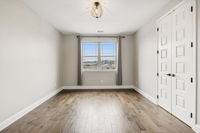 spare room with wood finished floors and baseboards