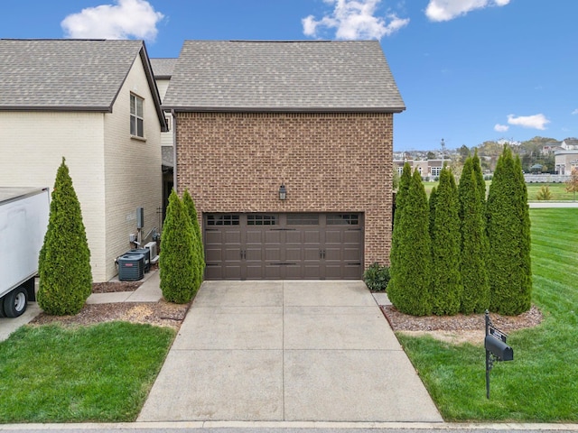 view of home's exterior featuring central AC unit, driveway, a shingled roof, a lawn, and brick siding