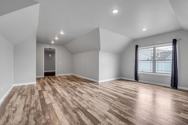 additional living space featuring vaulted ceiling, recessed lighting, wood finished floors, and baseboards