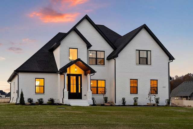 view of front of home with brick siding and a front lawn