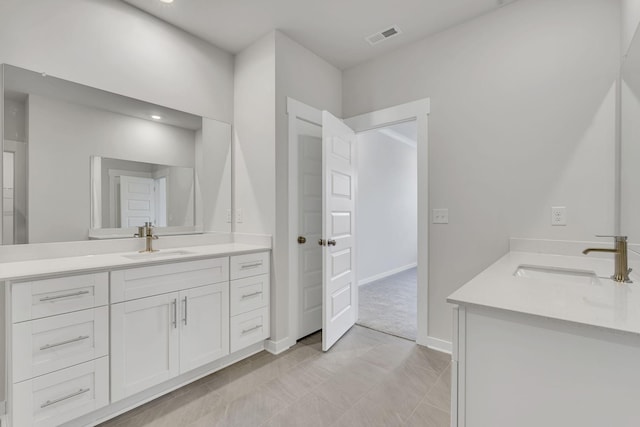 full bathroom featuring two vanities, a sink, visible vents, and baseboards