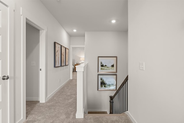 hallway featuring baseboards, carpet floors, an upstairs landing, and recessed lighting