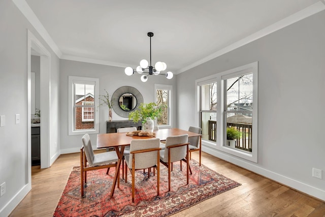 dining room with light wood-type flooring, an inviting chandelier, and a wealth of natural light