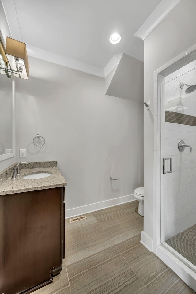 bathroom featuring visible vents, toilet, a stall shower, vanity, and baseboards