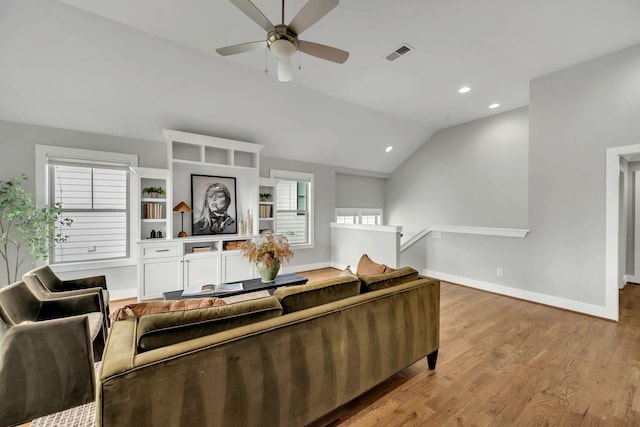 living room featuring vaulted ceiling, baseboards, visible vents, and light wood-style floors