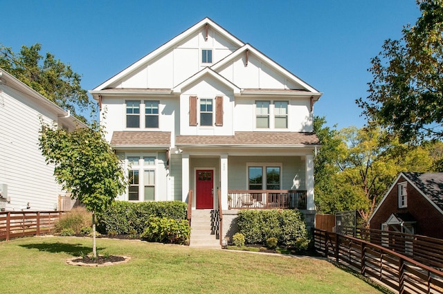 view of front of home with a porch, a shingled roof, fence, board and batten siding, and a front yard