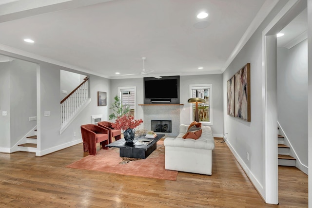 living area with plenty of natural light, stairway, a fireplace, and light wood-style floors