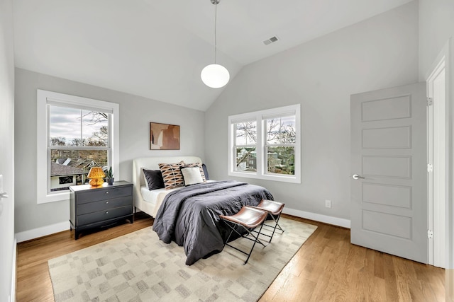 bedroom featuring lofted ceiling, wood finished floors, and baseboards