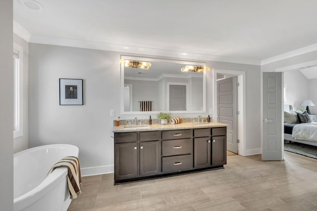 bathroom with double vanity, a sink, a freestanding bath, and ensuite bathroom