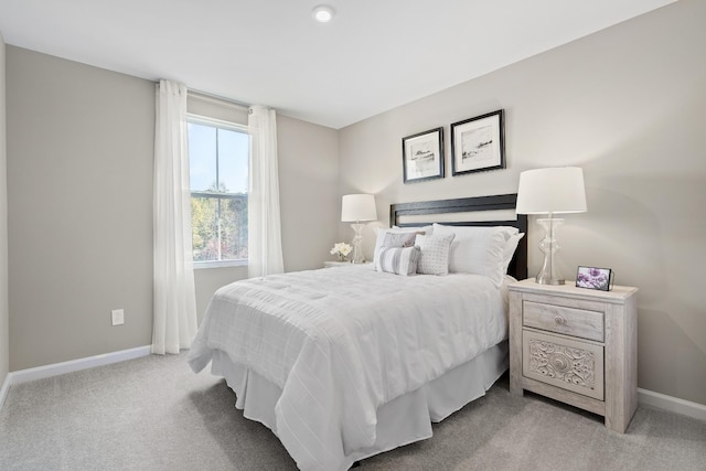 bedroom featuring light carpet and baseboards