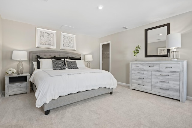 bedroom with light colored carpet, a closet, visible vents, and baseboards