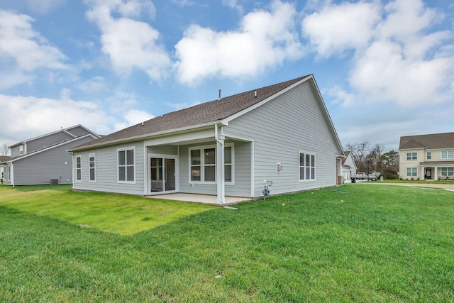 rear view of house with a lawn and a patio