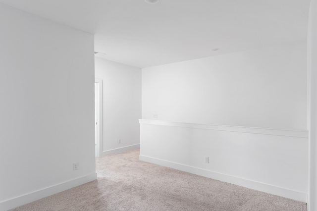 spare room featuring carpet flooring and baseboards