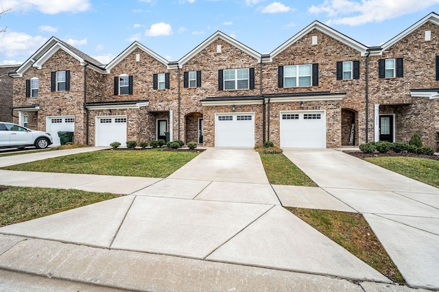 multi unit property with an attached garage, brick siding, driveway, and a front lawn