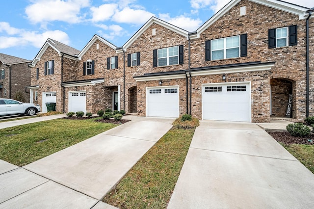 view of front of house with driveway, an attached garage, and brick siding