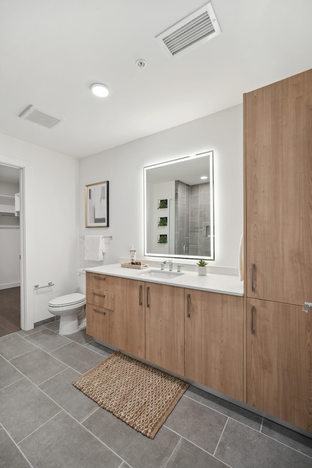 bathroom featuring vanity, tile patterned floors, toilet, and visible vents