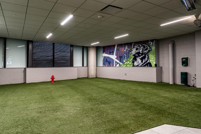 carpeted empty room featuring concrete block wall