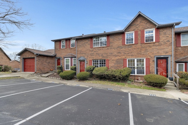 townhome / multi-family property featuring uncovered parking and brick siding