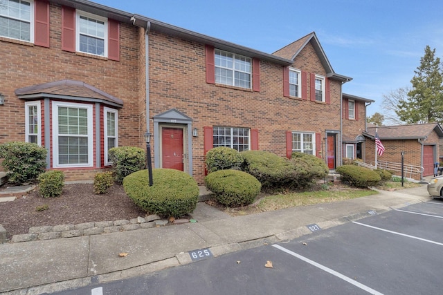 multi unit property featuring uncovered parking and brick siding