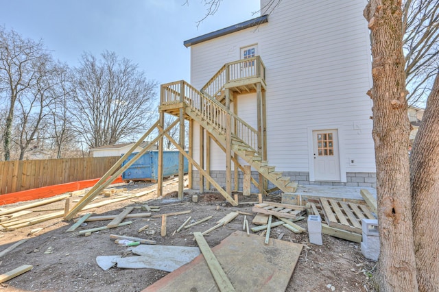 back of house featuring stairs and fence