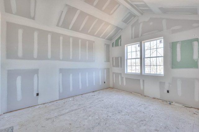 unfurnished room with vaulted ceiling