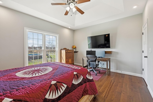 bedroom featuring recessed lighting, a raised ceiling, baseboards, and wood finished floors