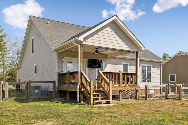 back of property with a lawn, a ceiling fan, a gate, fence, and a wooden deck