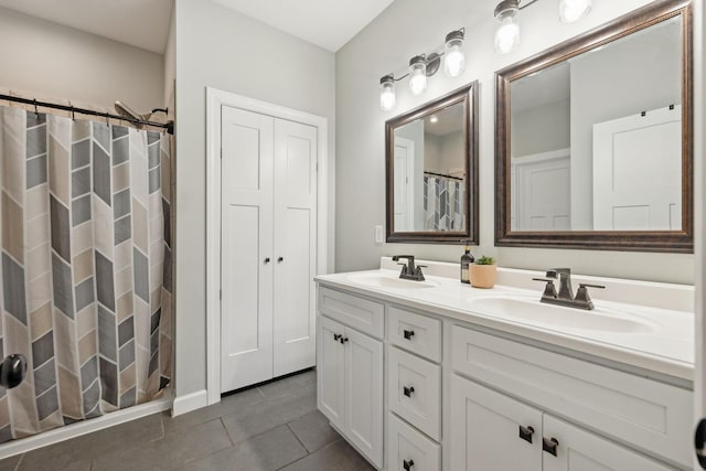 bathroom with double vanity, a shower with curtain, a sink, and tile patterned floors