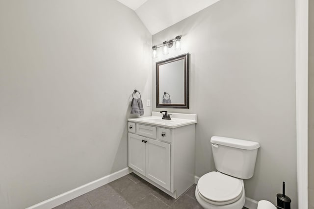 bathroom featuring lofted ceiling, vanity, toilet, and baseboards
