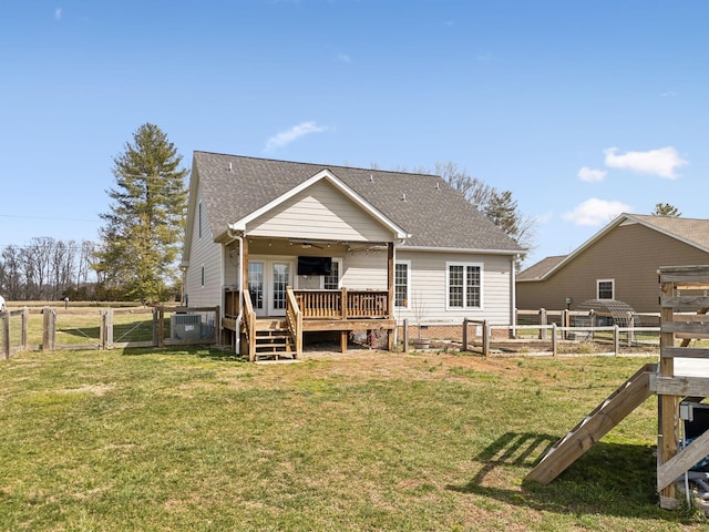 rear view of property with a fenced backyard, french doors, a lawn, a wooden deck, and a gate