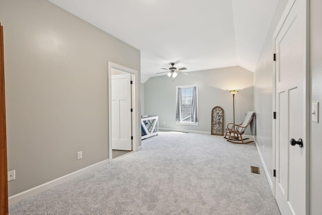 interior space featuring vaulted ceiling, carpet flooring, a ceiling fan, and baseboards