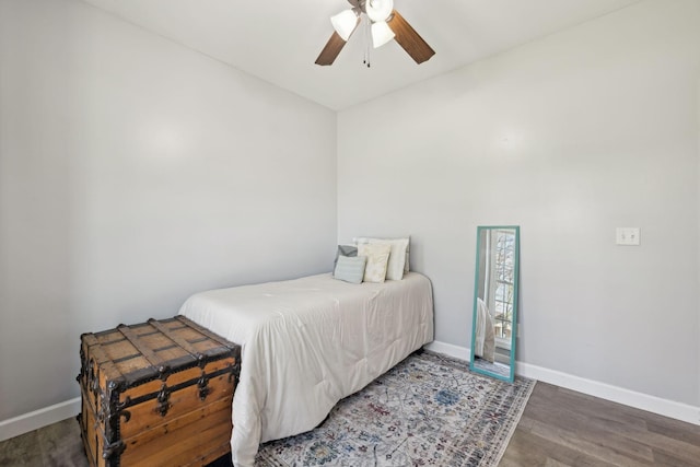 bedroom with ceiling fan, wood finished floors, and baseboards