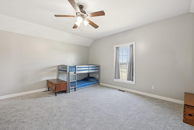 bedroom with a ceiling fan, visible vents, vaulted ceiling, baseboards, and carpet