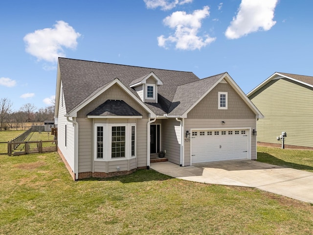 view of front of home with an attached garage, roof with shingles, concrete driveway, and a front yard