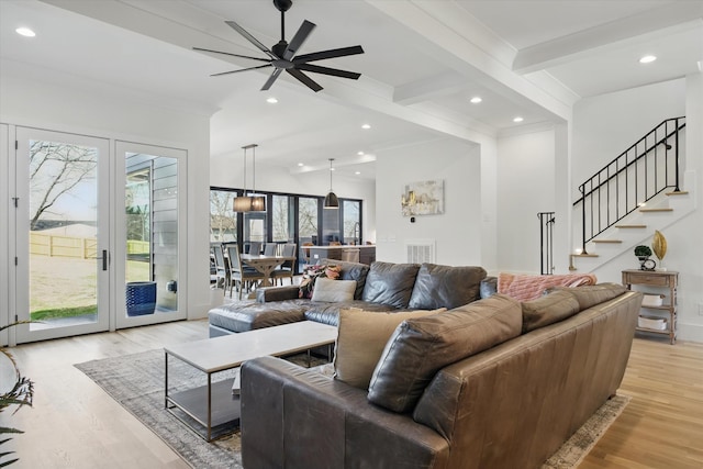 living room with recessed lighting, visible vents, light wood-style floors, beamed ceiling, and stairs