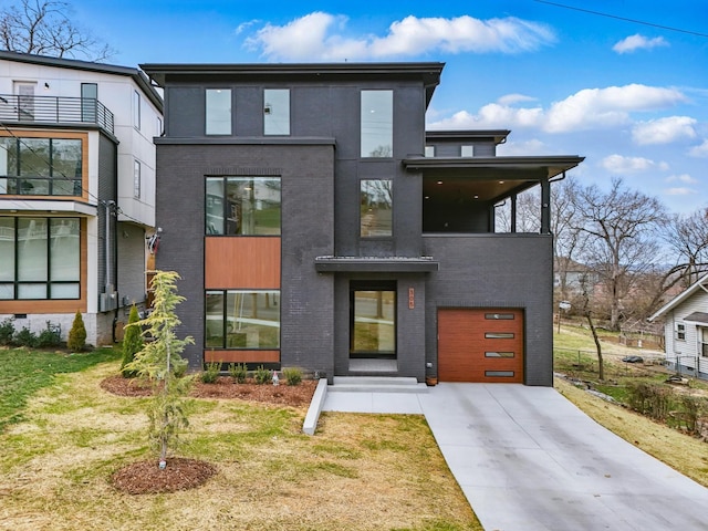 modern home with concrete driveway, brick siding, and an attached garage