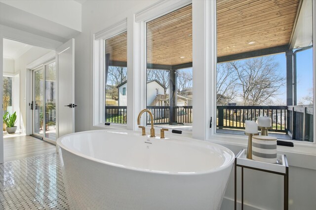 full bath featuring a freestanding bath and wood finished floors