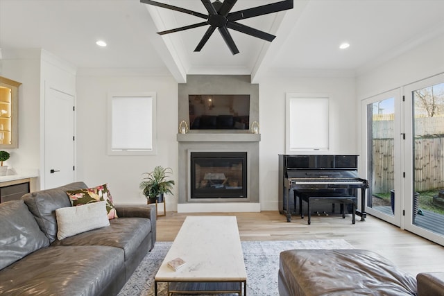 living area with a glass covered fireplace, ornamental molding, light wood-style floors, beam ceiling, and recessed lighting