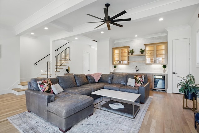 living area with light wood-type flooring, beverage cooler, stairway, and beam ceiling