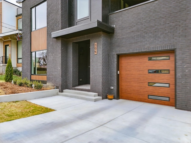 entrance to property featuring brick siding and an attached garage