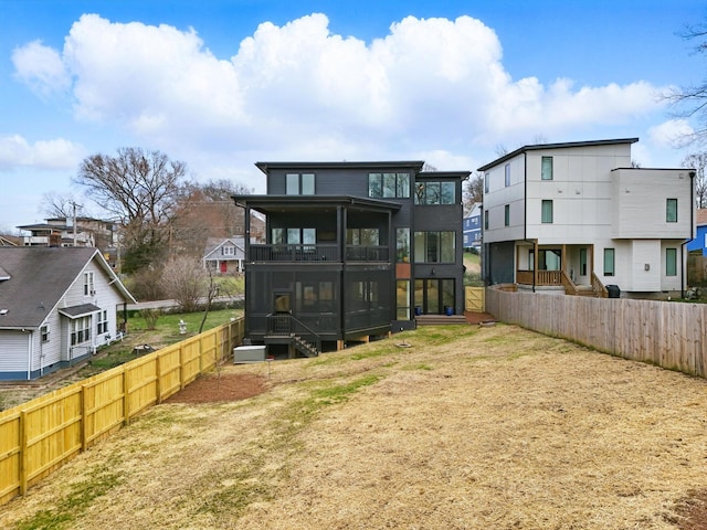 back of house featuring a residential view, a sunroom, fence, and a balcony