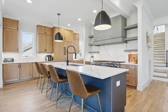 kitchen with a sink, wall chimney exhaust hood, light wood-type flooring, range, and open shelves