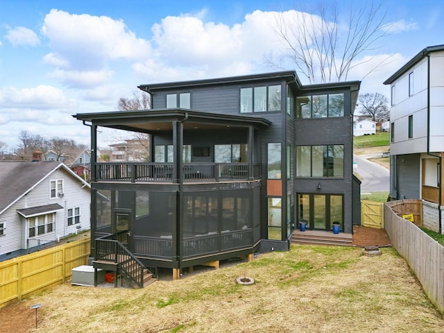 rear view of house featuring a sunroom and a fenced backyard