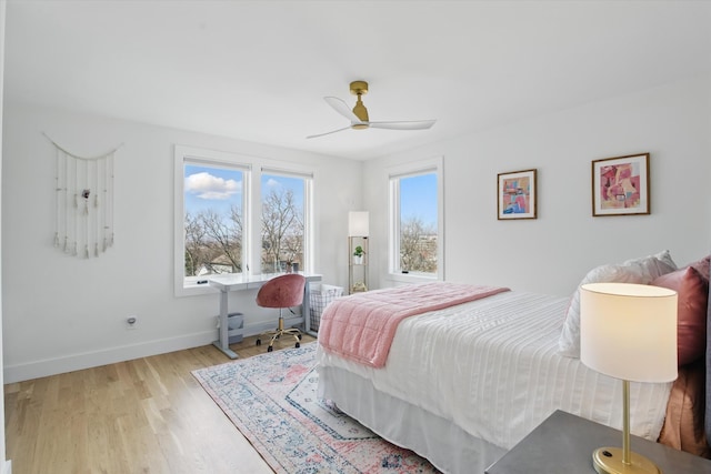 bedroom featuring ceiling fan, baseboards, and wood finished floors