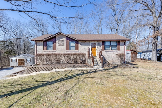 view of front of house with brick siding, a shingled roof, entry steps, an outdoor structure, and a front lawn