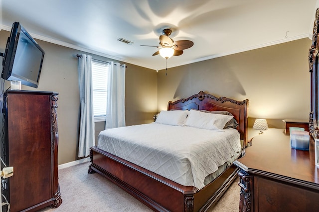 carpeted bedroom with baseboards, visible vents, ceiling fan, and ornamental molding