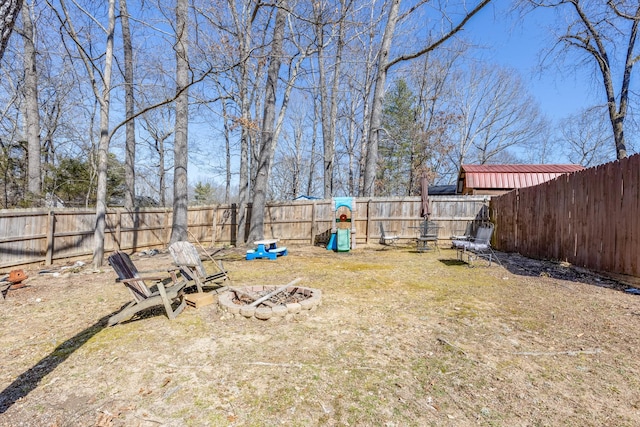 view of yard featuring a fenced backyard and a fire pit