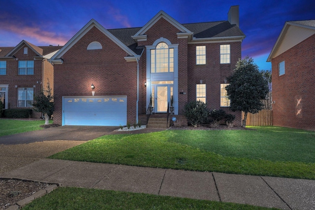 view of front of house featuring concrete driveway, brick siding, and a yard