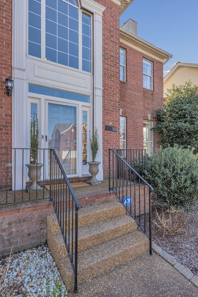 doorway to property featuring brick siding