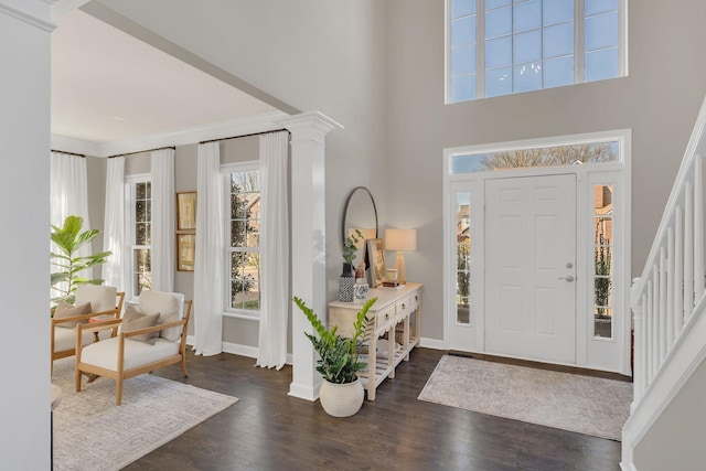 entryway with dark wood-style floors, stairs, and baseboards